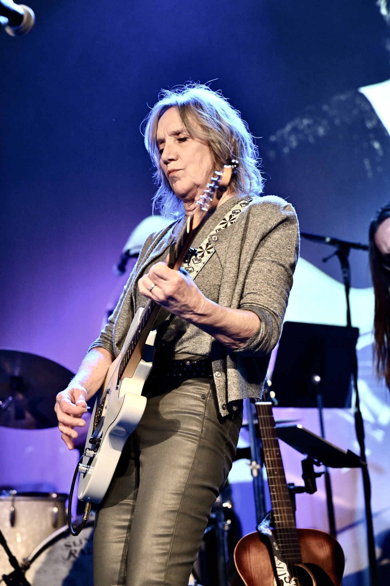 Anne Ducharme-Jones plays a guitar on stage.